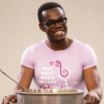 Chidi Anangoyne, a character from the Good place, smiles behind a large pot of chili with peeps and M&Ms in it.